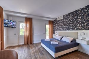 a bedroom with a bed and a tv on a wall at Da Oscar Flowers Apartments in Barcuzzi