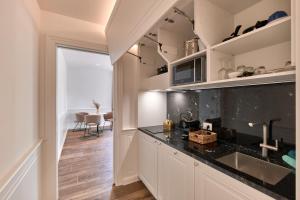 a kitchen with white cabinets and a black counter top at Da Oscar Flowers Apartments in Barcuzzi