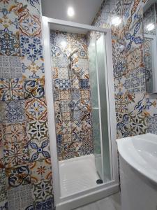 W łazience znajduje się prysznic i lustro. w obiekcie BOLANO HOUSE w Katanii
