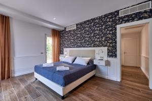 a bedroom with a bed with a blue comforter at Da Oscar Flowers Apartments in Barcuzzi