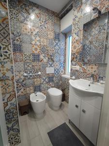 a bathroom with a sink and a toilet and tiles at BOLANO HOUSE in Catania