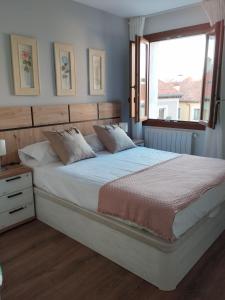 Schlafzimmer mit einem großen Bett und einem Fenster in der Unterkunft Rincón Gótico in Burgos