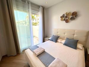 Benalmadena CostaにあるAtlantis Home PUERTO MARINA - 1 Minuto de la Playaのベッドルーム(大型ベッド1台、大きな窓付)