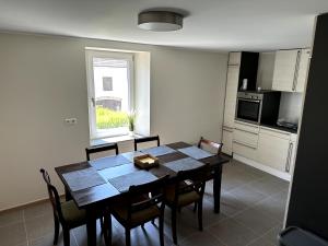 eine Küche mit einem Holztisch und Stühlen im Zimmer in der Unterkunft Deluxe Double Rooms Helfant Luxembourg 