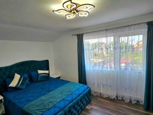 - une chambre avec un lit bleu et une fenêtre dans l'établissement Casa Laur, à Sulina
