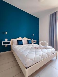 a bedroom with a large bed with a blue wall at La Residenza B&B in Giba