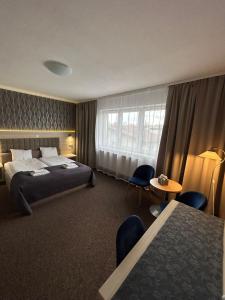 a hotel room with a bed and a table and chairs at Old Tree Villa & Restaurant in Oświęcim +127 photos