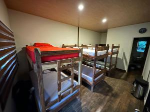 a room with several bunk beds in a room at Captain Morgan Hostel Lake Coatepeque in Santa Ana