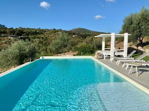 a swimming pool with two chairs and a table at La Casa di Alice Turchese in Olbia