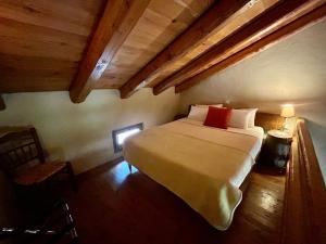 um quarto com uma cama grande num quarto com tectos em madeira em Pritanio em Polídhroson