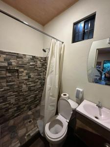 a bathroom with a toilet and a sink at Captain Morgan Hostel Lake Coatepeque in Santa Ana