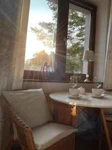a table and chair in front of a window at Apartamenty & SPA Villa 28 in Pobierowo