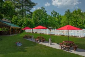 eine Gruppe Picknicktische mit roten Sonnenschirmen in der Unterkunft Christmas Farm Inn and Spa in Jackson