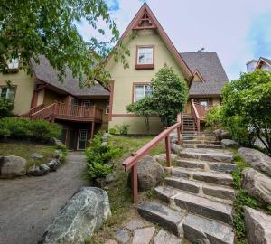 a house with a staircase in front of a house at Plateau 202-5/STUNNING 3bdr with POOL in Mont-Tremblant