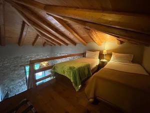 a bedroom with two beds and a stone wall at Pritanio in Polídhroson