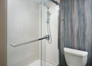 uma casa de banho com um WC e uma cabina de duche em vidro. em Marriott Knoxville Downtown em Knoxville