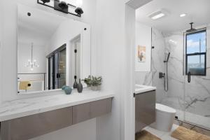 bagno bianco con servizi igienici e doccia di Modern Hollywood Charm a Los Angeles