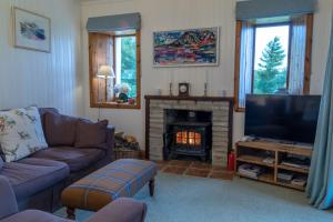 a living room with a couch and a fireplace at Ferroch the place with an amazing view! in Torridon
