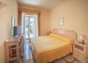 Un dormitorio con una cama grande y una ventana. en Hotel Royal Terme, en Isquia