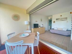 - une salle à manger et un salon avec une table et des chaises dans l'établissement Superbe T2 en rez de jardin à Port Camargue, au Grau-du-Roi