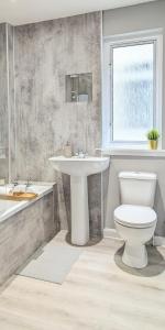 a bathroom with a toilet and a sink and a tub at Campbeltown View in Campbeltown