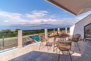 a patio with a table and chairs on a balcony at Villa Celeste in Supetar