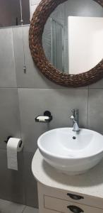W łazience znajduje się biała umywalka i lustro. w obiekcie Rietvlei at Margate Boulevard w mieście Margate