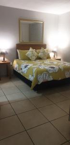 a bed in a bedroom with two lamps and a mirror at Rietvlei at Margate Boulevard in Margate
