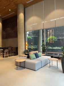a living room with a couch and tables at Radisson Pinheiros in São Paulo