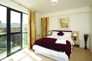 a bedroom with a large bed and a large window at SACO Derby in Derby