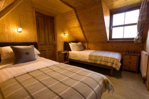 a bedroom with two beds in a wooden cabin at Ferroch the place with an amazing view! in Torridon