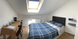 1 dormitorio con cama, mesa y ventana en Jey's Flat en Liverpool