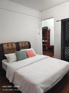 a bedroom with a large white bed with colorful pillows at Marina Terrace A1-10 in Port Dickson
