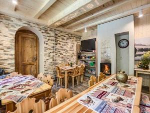 a dining room with two tables and a stone wall at Willa Wiktoria in Zakopane