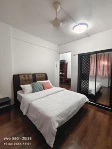 - une chambre dotée d'un grand lit avec des draps et des oreillers blancs dans l'établissement Marina Terrace A1-10, à Port Dickson