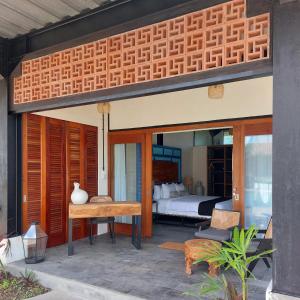 a patio with a table and a bed in a bedroom at Spaces Bali in Dalung