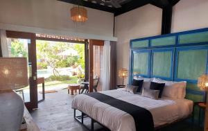 a bedroom with a large bed with a blue headboard at Spaces Bali Unique Boutique Hotel in Munggu