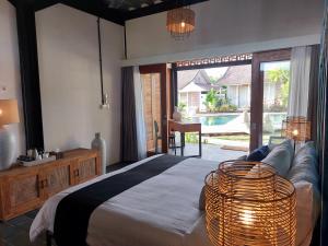 a bedroom with a bed and a couch and a table at Spaces Bali Unique Boutique Hotel in Munggu