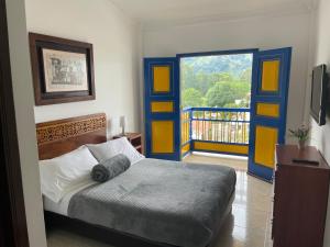 1 dormitorio con 1 cama y puerta con balcón en Hospedaje Camino Real a 150 MTS del centro, en Salento