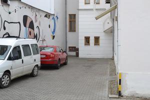 two cars parked in a parking lot next to a building at Ubytovna U Kašny in Uherské Hradiště