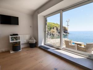 a room with a large window with a view of the ocean at Beach Cottage in Helston