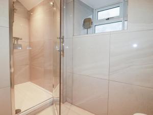 a shower with a glass door in a bathroom at Beach Cottage in Helston