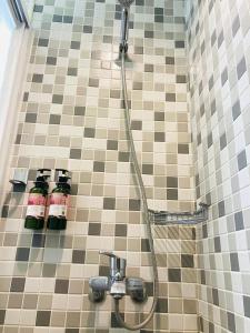a shower with two bottles on a tiled wall at 心適都蘭Comfy Inn, Dulan in Donghe