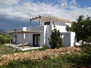 Casa blanca con pared de piedra en Casa Padel El Perello, en Perelló