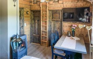 a dining room with a table and a fireplace in a cabin at Amazing Home In Mykland With Kitchen in Mykland