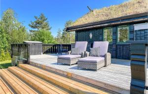 a wooden deck with two chairs and a house at Amazing Home In Mykland With Kitchen in Mykland