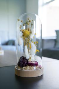 a glass dome with flowers in it on a table at Terrace Apartment in Airdrie