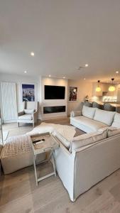 a living room with a white couch and a tv at Morelli Plaza Portstewart in Portstewart