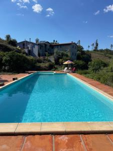 a large blue swimming pool with a building in the background at Quinta do Eco in Vila de Rei