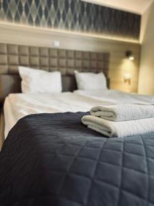 een slaapkamer met een bed met twee handdoeken erop bij Old Tree Villa & Restaurant in Oświęcim